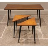 A teak veneered coffee table, circa 1970, the rectangular top on ebonised tapering cylindrical legs,