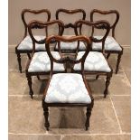 A set of six Victorian rosewood compressed balloon back dining chairs, each with a carved leafy