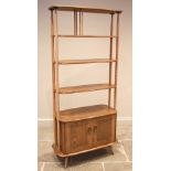 An Ercol honey elm and beech Windsor giraffe open bookcase, mid to late 20th century, formed with