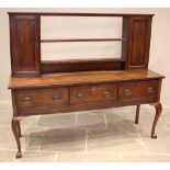 A George III oak dresser, the reduced plate rack with two open shelves flanked by spice cupboards,