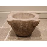 A large stone mortar, of typical tapering form, with four lug handles, 26cm high, interior well 30cm