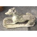 A reconstituted stone greyhound garden ornament, modelled in a recumbent position, 68cm long