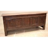 A 17th/18th century oak coffer, the moulded plank top opening to a later lined interior and a fitted
