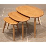 An Ercol nest of three blonde elm and beech pebble tables, late 20th century, the rounded table tops