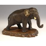 A Japanese bronze model of an elephant, Meiji Period (1868-1912), modelled standing with its trunk