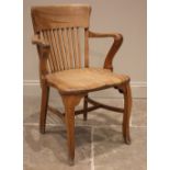 An early 20th century beech captains/desk chair, with a concave lath back over a shaped seat,