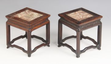 A pair of Chinese carved hard wood marble inset vase stands, each of square section inset with rouge