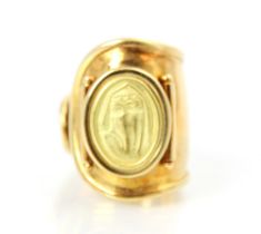 A yellow metal dress ring, the tapered open ring with applied oval pad depicting lady, ring size