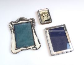 A group of three silver mounted photograph frames, each of rectangular form and of varying size, one