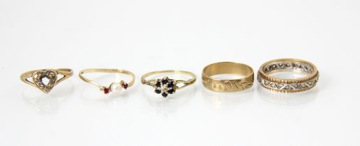 A selection of five rings, including a 9ct yellow gold band ring, with engraved continuous detail,