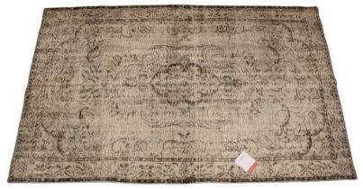 An Oka Haversham wool rug, in a green foliate design, 60% wool, 40% cotton, with retailer's original
