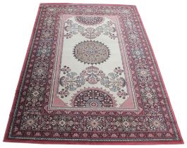 A floral pattern wool carpet in red, black and ivory colourways, the central ivory field with a