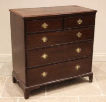 A George III oak straight front chest of drawers, formed with an arrangement of two short over three