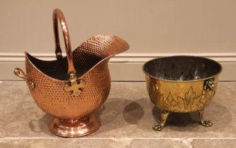 A late 19th century hammered copper coal scuttle, of helmet form with swing handle, 33cm high, along