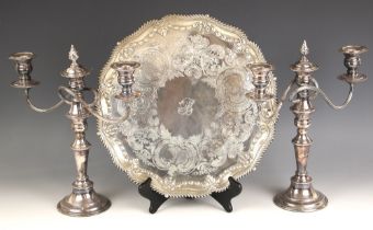 A pair of silver plate candelabra, the beaded rims above urn shaped sconces, with conforming stem