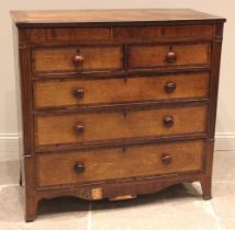 A George IV oak and mahogany crossbanded chest of drawers, formed with a pair of secret frieze