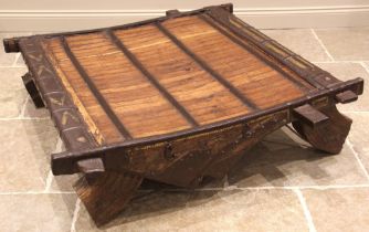 A 19th century iron bound hardwood coffee table, formed from an elephant saddle, upon substantial