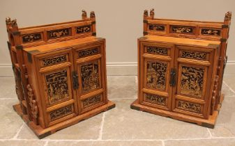 A pair of Chinese pine marriage chests, late 20th century, the relief moulded doors highlighted in