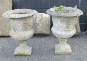 A pair of reconstituted garden urns, of campana form, with relief moulded foliate detail to the