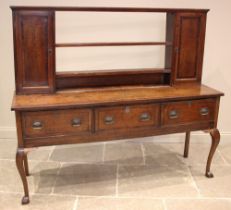 A George III oak dresser, the reduced plate rack with two open shelves flanked by spice cupboards,