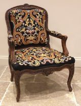 A Louis XV style stained beech and tapestry upholstered fauteuil, mid 20th century, the frame carved