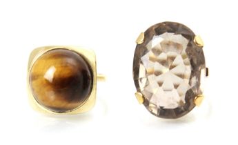 Two yellow metal dress rings, to including a tigers eye dress ring, the circular cabochon tigers eye