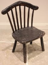 A small Welsh primitive oak comb back chair, early 19th century, the rough cut crescent shaped top