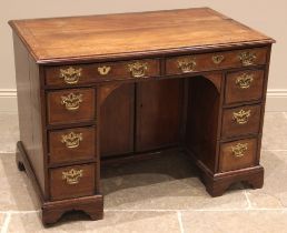 A George III mahogany kneehole desk, the moulded crossbanded top above a pair of oak lined frieze