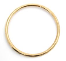 A 9ct yellow gold bangle, the hollow bangle with faceted detail to exterior, stamped Chester 1928,