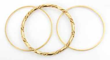 A pair of yellow metal bangles, with applied grooved detail, each engraved ‘22k’ 18gms, with a