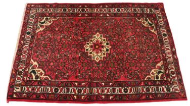 A hand knotted Iranian Herati rug, in red, green and ivory colourways, the central ivory geometric