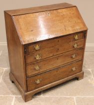 A George III fruitwood bureau, the cross-banded fall front opening to a compartmented interior, over