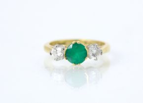 An 18ct yellow gold untested emerald and diamond three stone ring, the central round cut green stone