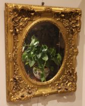 A giltwood and composite rococo style wall mirror, late 20th century, the relief moulded shell and