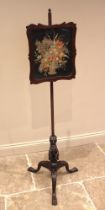 A mahogany pole screen, mid 19th century, the shaped and glazed embroidered silk work panel