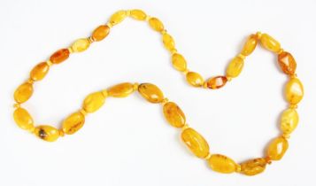 A string of butterscotch coloured amber beads, the graduated non uniform shaped beads interspersed