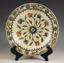 An Islamic Iznik Safavid Empire plate, of circular shallow form and decorated with a central foliate