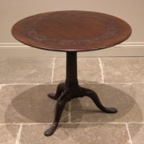 A George II red walnut tripod table, possibly Irish, the circular top with an incised scroll frieze,