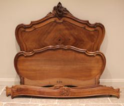 A French walnut bed, late 19th/early 20th century, the shaped headboard with a carved shell and