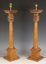 A pair of neo-classical style oak table lamps, late 20th century, the square stepped capitals raised