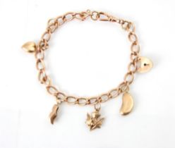 A yellow metal charm bracelet, the curb links suspending five gold coloured charms including
