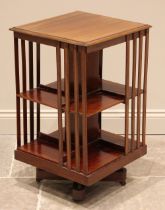 An Edwardian mahogany revolving bookcase, the moulded square top over twin tiers each with four