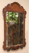 A George III mahogany fretwork girandole wall mirror, the arched and scrolled frame enclosing the