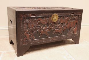 A Chinese carved camphor chest, mid 20th century, the hinged cover carved in deep relief with a