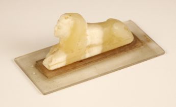 An Egyptian Grand Tour carved alabaster Sphinx, modelled upon a perspex base, carving 9.5cm long