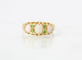 An 18ct yellow gold opal and demantoid garnet ring, the central oval cabochon opal with a further