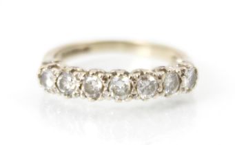 A late 20th century 18ct white gold diamond half eternity ring, the seven round cut diamonds