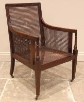 An Edwardian mahogany bergere library chair, the rectangular cane work back extending to down