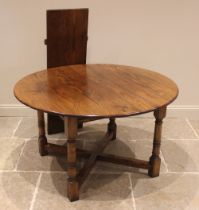 An 18th century style oak draw leaf dining table, late 20th century, the circular top with
