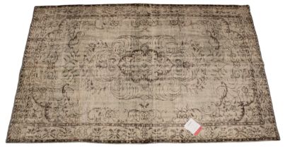 An Oka Haversham wool rug, in a green foliate design, 60% wool, 40% cotton, with retailers